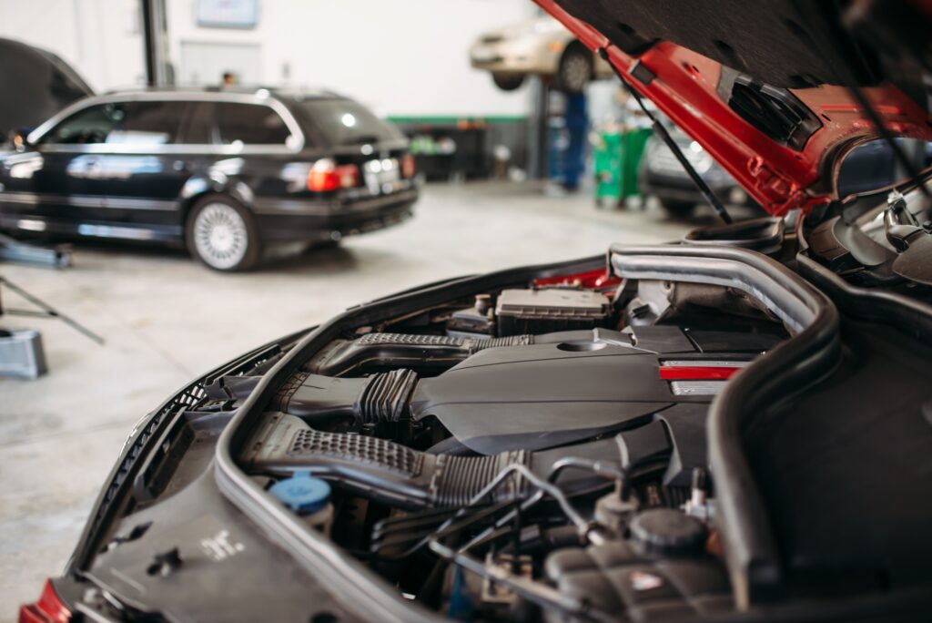 Car with opened hood in automobile service