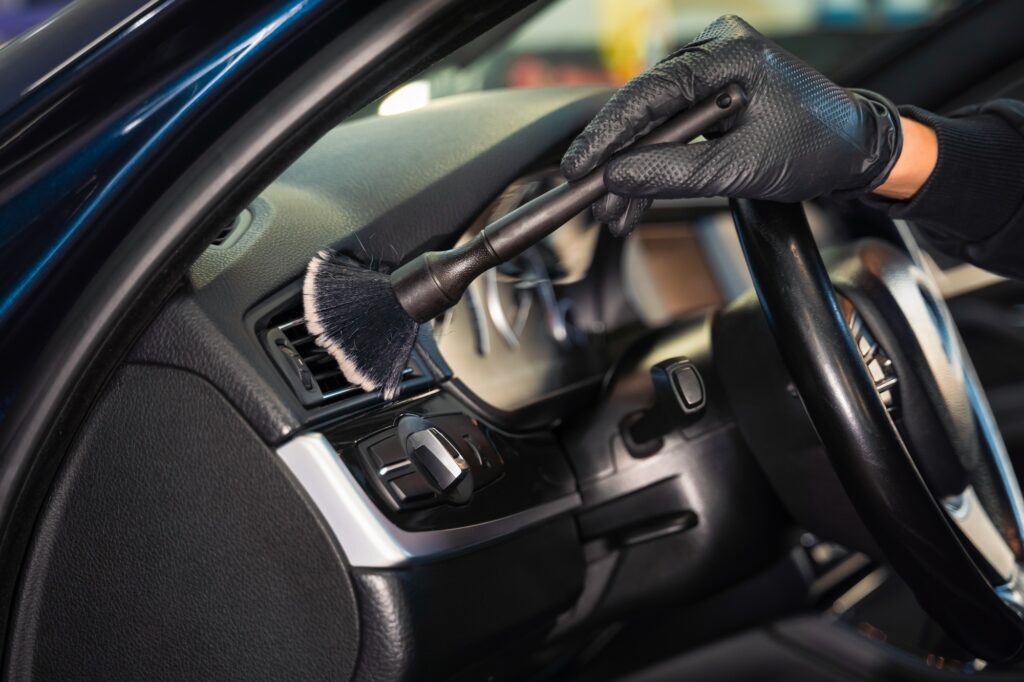 Cleaning car vent with brush. Auto detailing concept